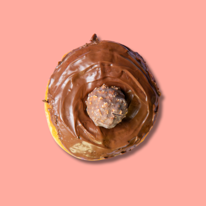 Top-down view of Ferrero chocolate donut with hazelnut topping on pink background – Go Nuts Donuts Nairobi